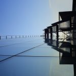 A striking glass skyscraper reflecting blue skies, showcasing modern architecture's elegance.